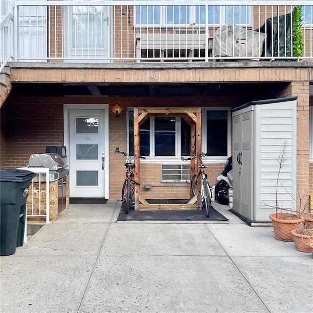 doorway to property with brick siding and a balcony