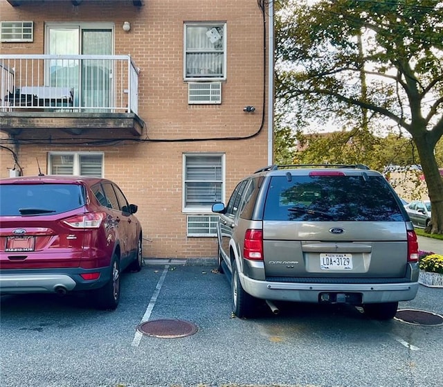 view of side of property featuring uncovered parking and brick siding