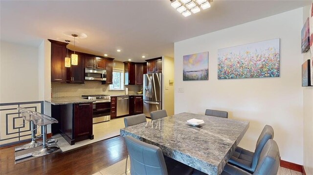 dining space featuring wood finished floors and recessed lighting
