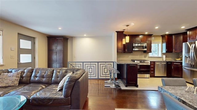living room with light wood-type flooring and recessed lighting