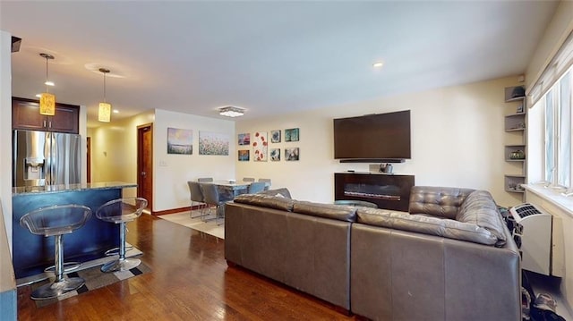 living area featuring recessed lighting, baseboards, and dark wood-style floors