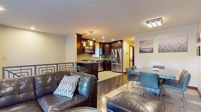 living area featuring light wood-type flooring and recessed lighting