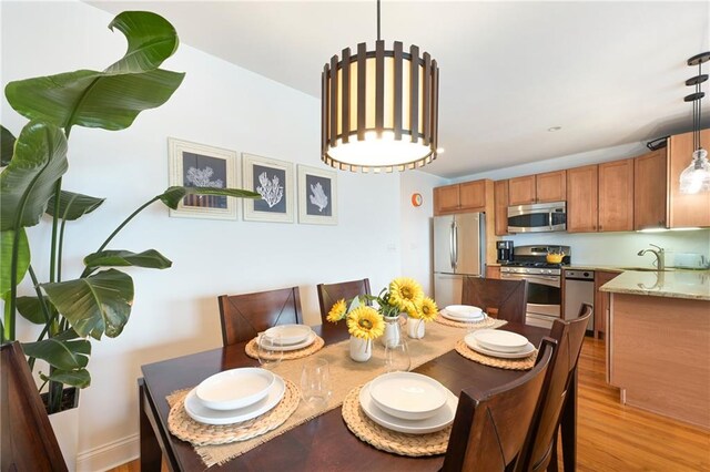 dining area featuring sink and light wood-type flooring