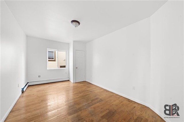 unfurnished room with wood-type flooring and a baseboard radiator