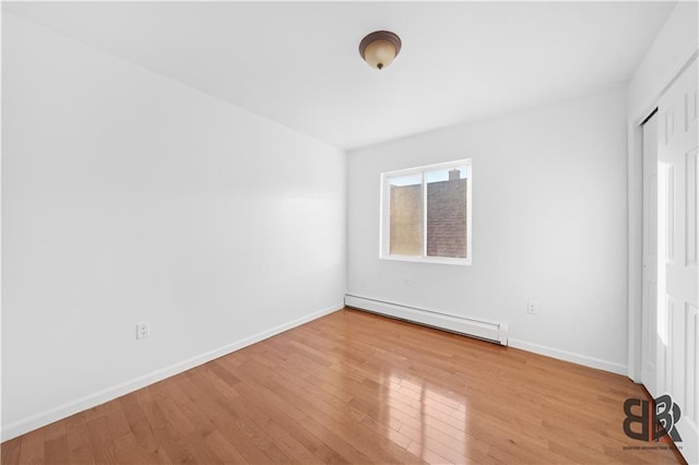 spare room with light hardwood / wood-style flooring and a baseboard radiator