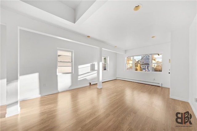 unfurnished living room with light hardwood / wood-style flooring and a baseboard radiator