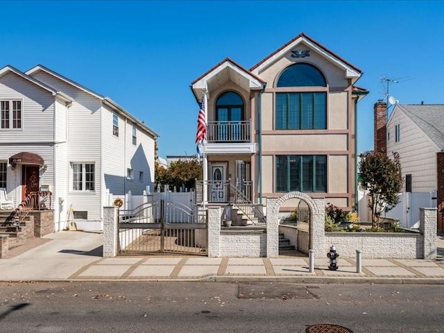 view of front facade with a fenced front yard, a gate, and stucco siding