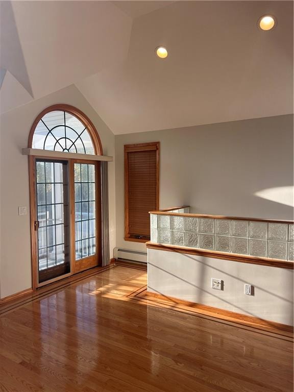 interior space featuring lofted ceiling, recessed lighting, baseboards, baseboard heating, and light wood-type flooring