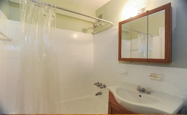 bathroom with vanity, decorative backsplash, and shower / bath combo with shower curtain