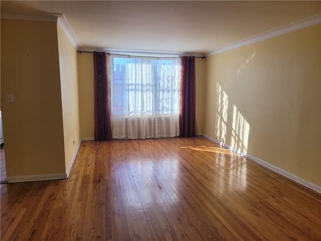 unfurnished room with baseboards, wood-type flooring, and ornamental molding