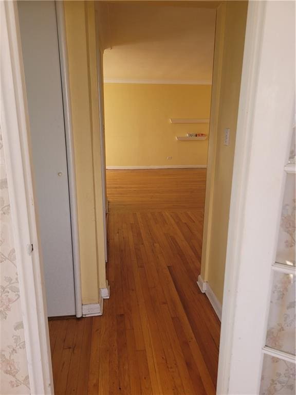 hall with baseboards and hardwood / wood-style floors