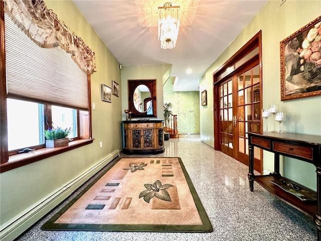 corridor featuring a baseboard heating unit, french doors, and a chandelier