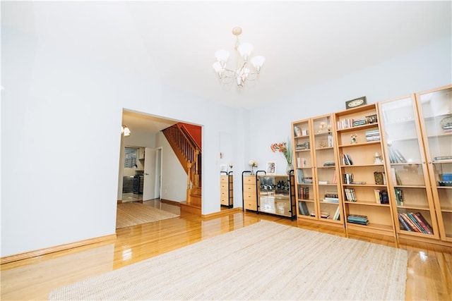 interior space featuring an inviting chandelier, stairway, and wood finished floors