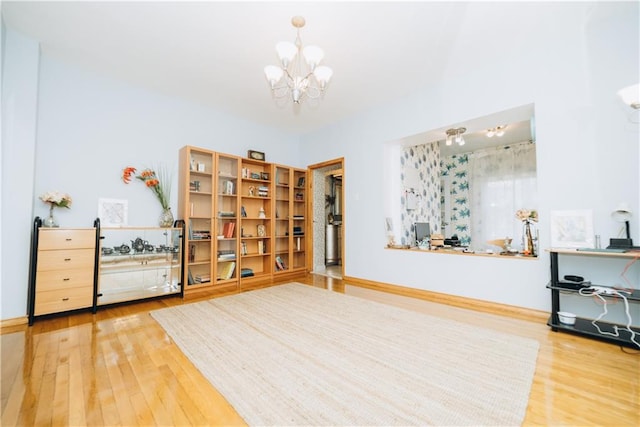 interior space featuring wood finished floors, baseboards, and a chandelier