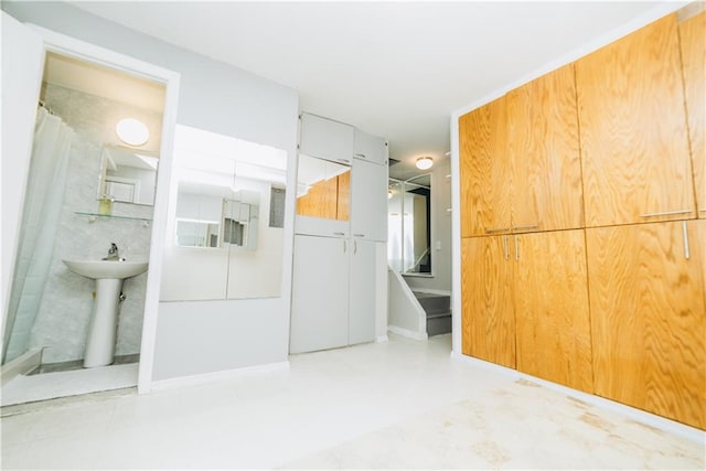 interior space with a shower with curtain and a sink