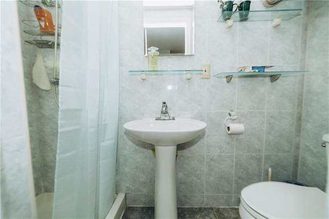 full bathroom featuring a stall shower, toilet, and tile walls