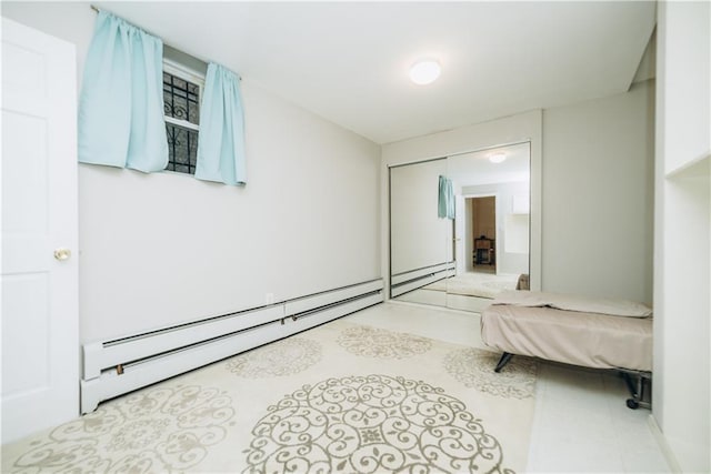 bedroom with a baseboard radiator and a closet