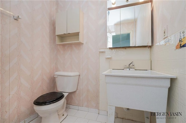 bathroom featuring vanity, tile patterned floors, toilet, and tile walls