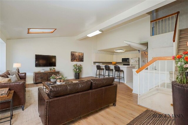 living room featuring vaulted ceiling and light wood-type flooring