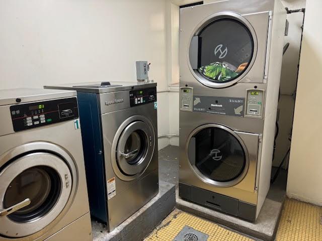 clothes washing area featuring stacked washer / drying machine and washing machine and dryer