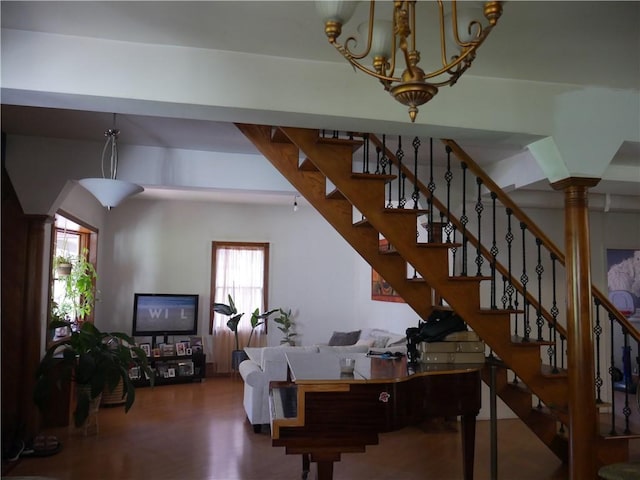 stairs with decorative columns and wood-type flooring