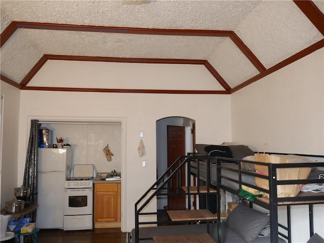 stairway with ornamental molding, hardwood / wood-style floors, vaulted ceiling, sink, and a textured ceiling