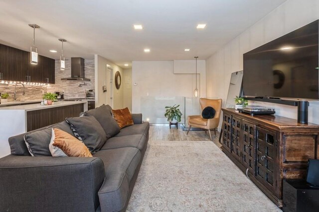 living room featuring sink and light hardwood / wood-style flooring