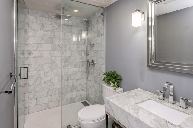 bathroom featuring an enclosed shower, vanity, and toilet