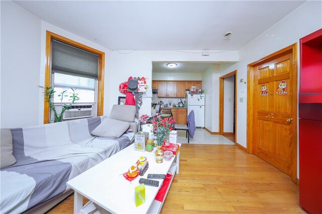 living room featuring baseboards, cooling unit, and light wood-type flooring