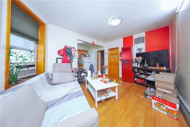 living room with light wood-style floors, a baseboard heating unit, and cooling unit