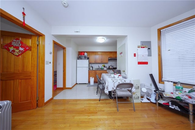 dining room with baseboards and light wood finished floors