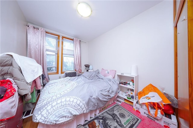 bedroom with wood finished floors and lofted ceiling