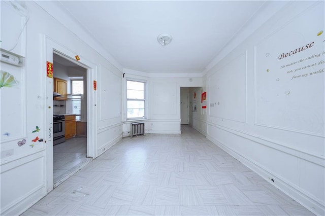 unfurnished room with radiator and a decorative wall