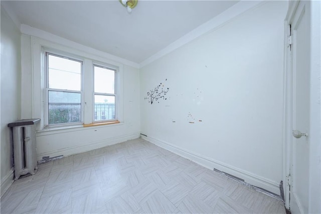 empty room with baseboards, ornamental molding, and radiator heating unit