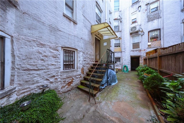 doorway to property with fence and stone siding