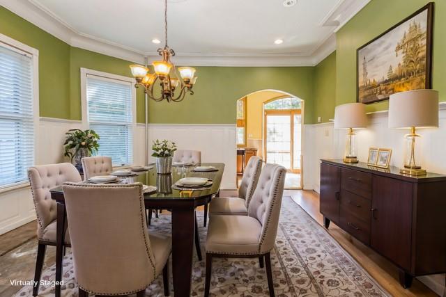 dining area with ornamental molding, light hardwood / wood-style flooring, and an inviting chandelier