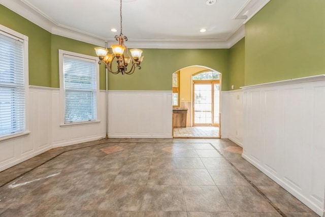 tiled spare room with crown molding and a notable chandelier