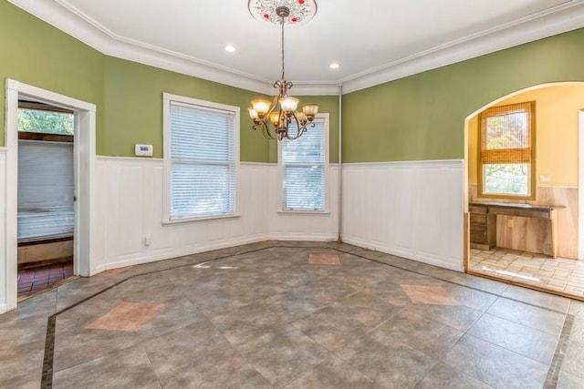 unfurnished dining area with ornamental molding and a chandelier