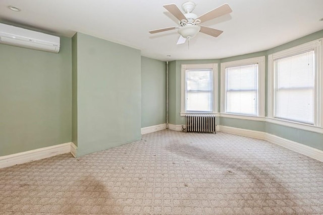 carpeted spare room with a wealth of natural light, a wall mounted AC, radiator heating unit, and ceiling fan