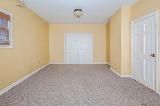 unfurnished bedroom with light colored carpet and a closet