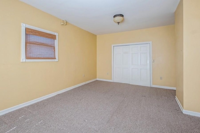 unfurnished bedroom featuring light colored carpet and a closet