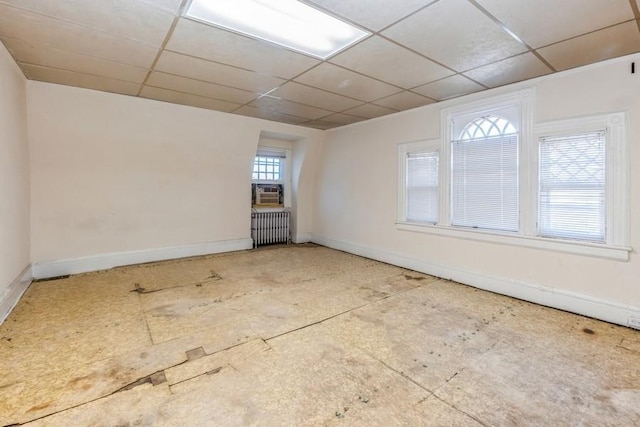 empty room with radiator heating unit and a paneled ceiling