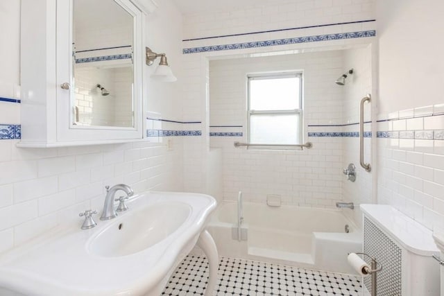 bathroom with tile patterned floors, radiator heating unit, tiled shower / bath combo, and tile walls