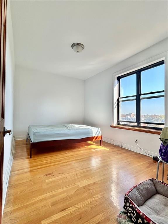 bedroom with light wood-type flooring and baseboards