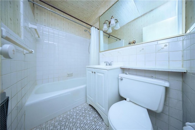 full bathroom featuring shower / bath combo with shower curtain, vanity, tile walls, and toilet