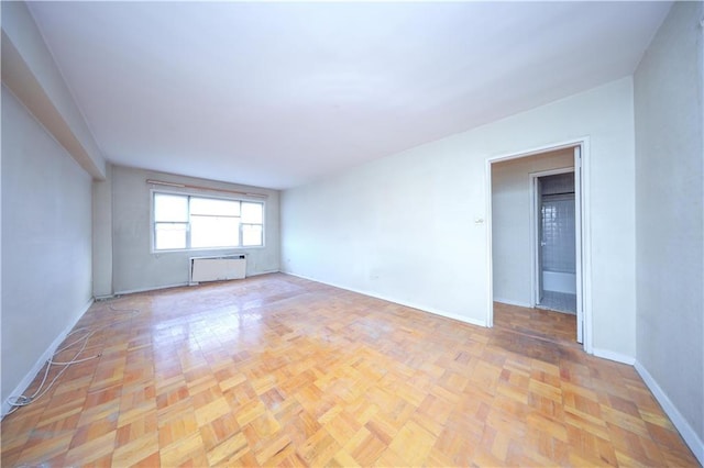 unfurnished room with light parquet floors and radiator