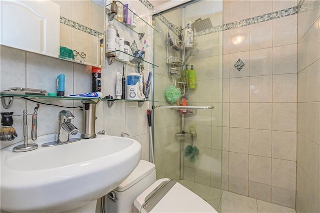 bathroom featuring toilet, backsplash, sink, and walk in shower