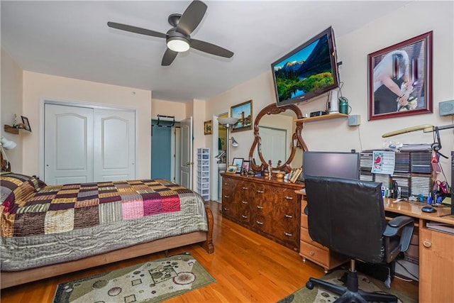 bedroom featuring ceiling fan, light wood-type flooring, and a closet