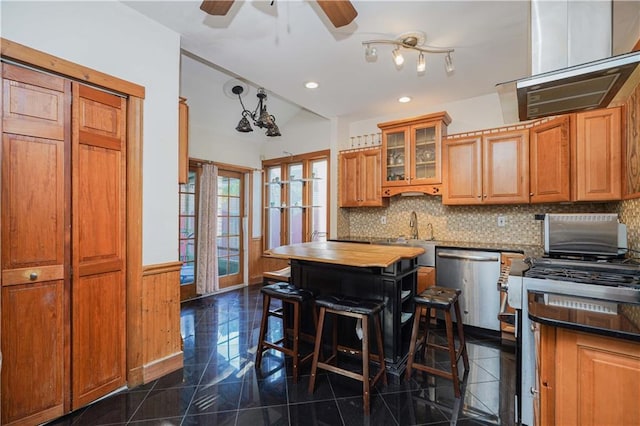 kitchen with dishwasher, sink, tasteful backsplash, a kitchen breakfast bar, and dark tile patterned floors