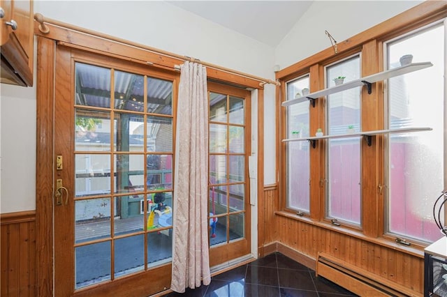 entryway with wooden walls, lofted ceiling, a wealth of natural light, and a baseboard heating unit